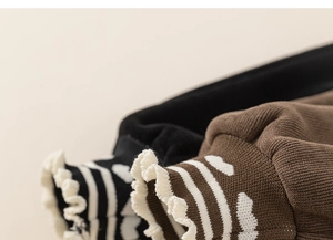 Détail des poignets côtelés avec motifs de cœur et bords volantés sur pantalon enfant
