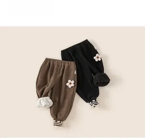 Détails de la doublure polaire et broderie florale sur pantalon en velours
