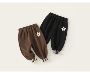Détail de deux pantalons de jogging doublés pour enfants avec appliques florales et ourlets
