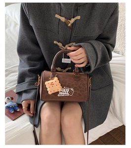 Detail of leopard print faux suede Boston bag with a cute biscuit plush charm