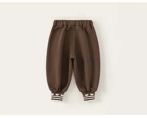 Détail du bas de pantalon marron avec motifs de cœurs blancs et bords à volants