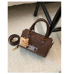 Deep brown leopard print boston bag with dual handles and a cute biscuit plush charm