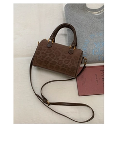Top view of faux suede leopard print boston bag with leather handles and gold hardware