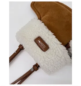 Detailaufnahme von braunem Wildleder und weißem Webpelz mit CLEAR K Lederetikett