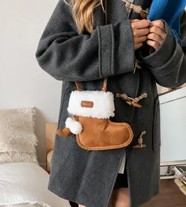Detail van de suède crossbodytas in de vorm van een laars met witte rand van imitatiebont