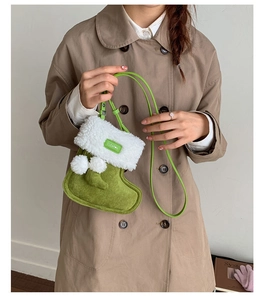 Detail der avocadogrünen Wildledertasche in Stiefelform mit weißem Webpelzbesatz