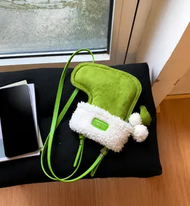 Detail van groene kerstsoktas van imitatie suède met witte pluche rand en zachte pompons