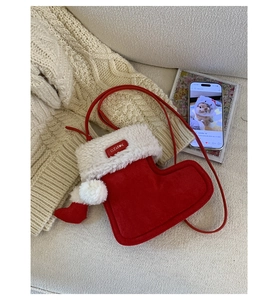 Platliggende rode suède kerstlaars-crossbodytas met witte imitatiebontrand en riem