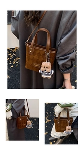 Detail of retro brown quilted suede bucket bag with bear charm and thin shoulder strap