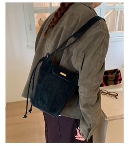 Sac seau en daim noir mat à la mode avec boucle en métal doré sur la bandoulière réglable