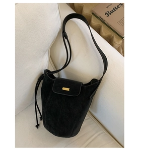 Vue détaillée du sac seau noir mat avec boucle en métal doré et cordons de serrage latéraux