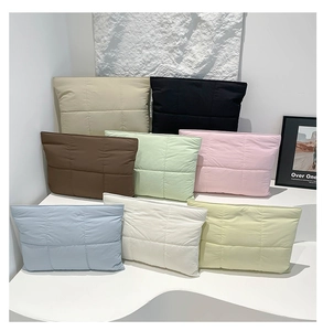 Mehrere Farben gesteppter Nylontaschen präsentiert in einem modernen minimalistischen Raum