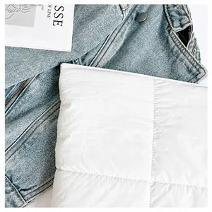 Detailaufnahme von weißem Steppmuster und Denim-Textur der minimalistischen Tragetasche