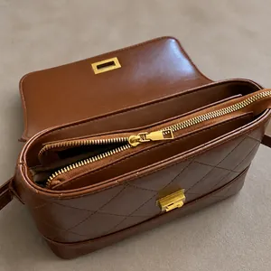 Dettaglio borsa in pelle trapuntata marrone con chiusura dorata e tasca interna