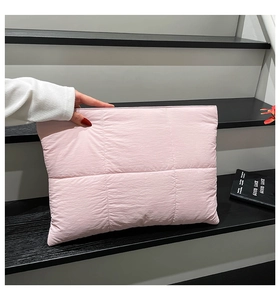 Detailansicht der rosa gesteppten Handtasche mit Karomuster auf minimalistischer Treppe