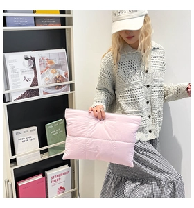 Detail der hellrosa gesteppten Clutch mit weich gepolsterter Stoffstruktur und Karomuster