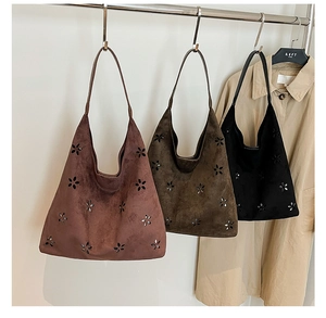 Detailed laser-cut floral pattern on vintage suede tote bags in various colors