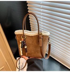 Détail du sac seau en daim marron avec bordure en fausse fourrure blanche et perles