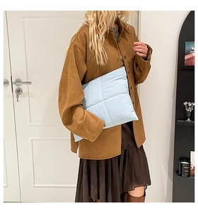Nahaufnahme der hellblauen gesteppten Nylon-Tragetasche mit weicher Polsterung am Modell