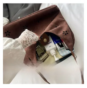 Detail of spacious vintage brown suede tote interior with flower laser cutouts and storage
