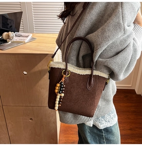 Détail du sac seau en daim marron avec bordure en peau lainée blanche et perles en bois