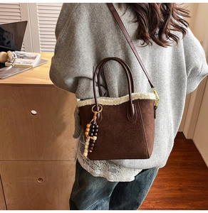 Détail de la bordure en polaire sur un sac seau vintage en daim marron avec breloque bois