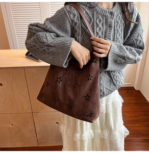 Detail of vintage chocolate brown suede tote bag with intricate floral hollow-out patterns