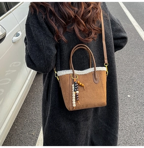 Sac seau en nubuck marron avec bordure en fourrure blanche et pompon en perles