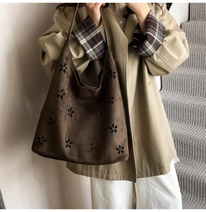 Detail of dark coffee suede tote bag featuring floral laser-cut patterns and large capacity