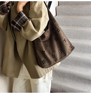 Detailed close-up of dark brown suede tote bag featuring laser-cut floral patterns