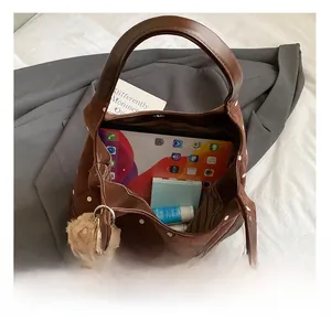 Spacious interior of brown polka dot suede tote bag holding a tablet and daily items