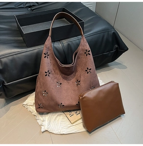 Detail of vintage brown suede tote bag with laser-cut floral patterns and inner pouch