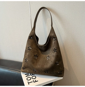 Detailed close-up of dark brown suede tote bag featuring laser-cut floral patterns