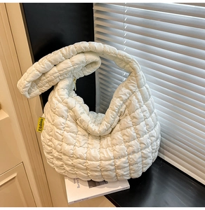 Détail du sac cabas matelassé blanc avec étiquette Fashion jaune et texture nuageuse