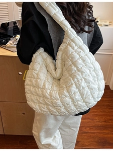 Sac à bandoulière matelassé blanc minimaliste avec étiquette Fashion porté par un modèle