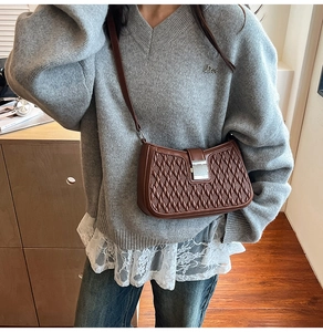 Brown quilted crossbody bag with silver buckle and woven texture on a model