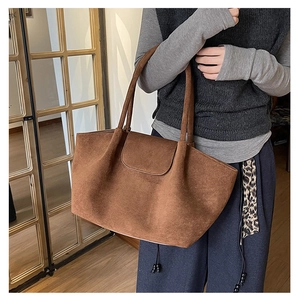 Detalle de un bolso tote de ante marrón con un acabado mate texturizado y gran capacidad