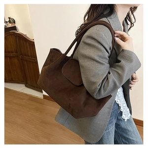 Bolso tote de ante marrón mostrado en modelo para referencia de tamaño de gran capacidad