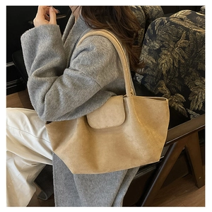 Detalle del bolso tote de ante camel con gran capacidad y cierre de solapa superior