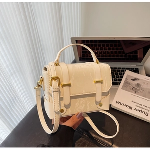 Detailweergave van de crème PU-leren handtas met marmertextuur en gouden metalen gespen