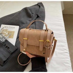Detail van de beige crossbodytas met geplooide textuur en gouden metalen ornament