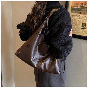 Detailed close-up of dark brown hobo bag with star-shaped laser cutouts and soft leather