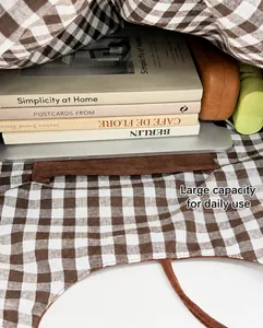 Interior view of large capacity brown and white checkered tote bag showing laptop and books