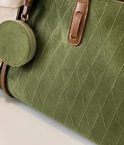 Detail of olive green quilted suede tote with detachable round coin purse and brown strap