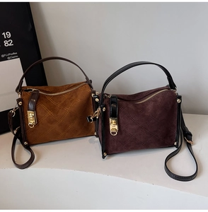 Detail of caramel and burgundy suede crossbody bag with elegant diamond quilted stitching