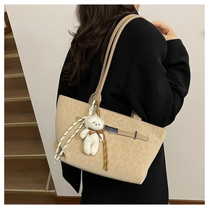 Détail du sac cabas léopard avec accents métalliques et accessoire charmant d'ours blanc