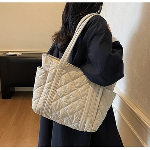 Détail du grand sac cabas matelassé avec poche latérale et coutures en losanges texturées