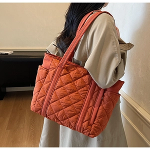Détail du cabas orange en nylon matelassé avec motif losanges et poche latérale