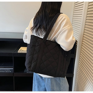 Vue arrière d'un grand sac cabas noir matelassé avec surpiqûres sur un mannequin