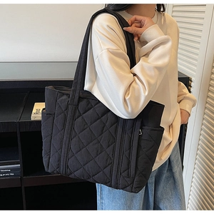 Détail du grand sac cabas noir matelassé avec poche latérale et bandoulière rembourrée